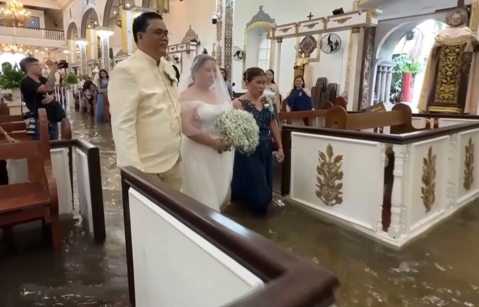 Tuf&atilde;o causa alagamento, mas noivos mant&ecirc;m casamento em Bulacan. &mdash; Foto: Reprodu&ccedil;&atilde;o v&iacute;deo