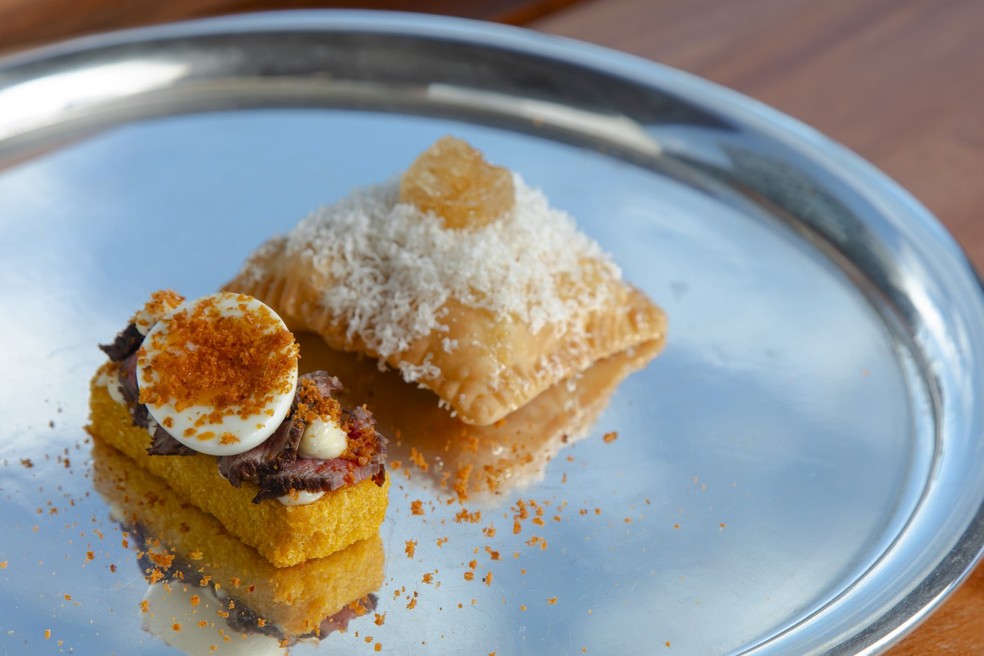 Polenta com wagyu desfiada e ovo ao lado de pastel de jiló com queijo — Foto: Leo Martins / Agência O Globo