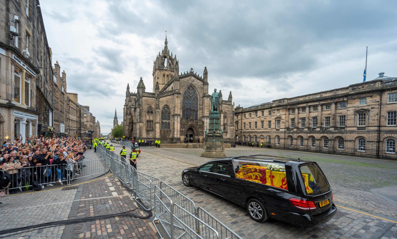 Carro funerário leva o caixão da Rainha Elizabeth II, envolto no Padrão Real da Escócia, passa pela Catedral de St. Giles, em Edimburgo, a caminho do Palácio de Holyroodhouse — Foto: Andrew O'Brien / AFP