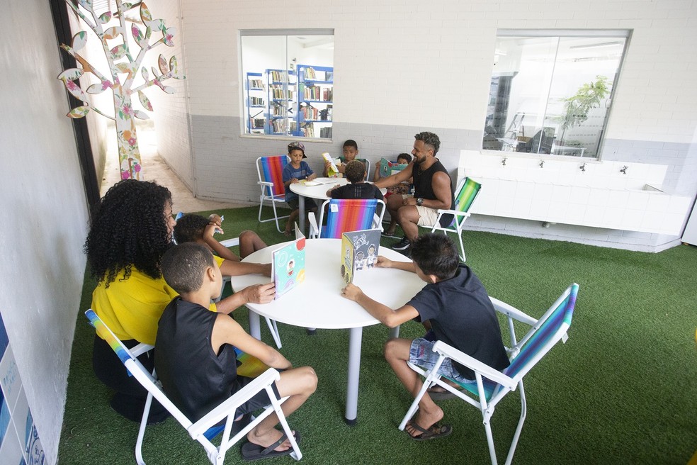 Sandra (de amarelo) com as crianças na Biblioteca Jorge Amado, na Maré: Perfil infantil - Foto: Domingos Peixoto