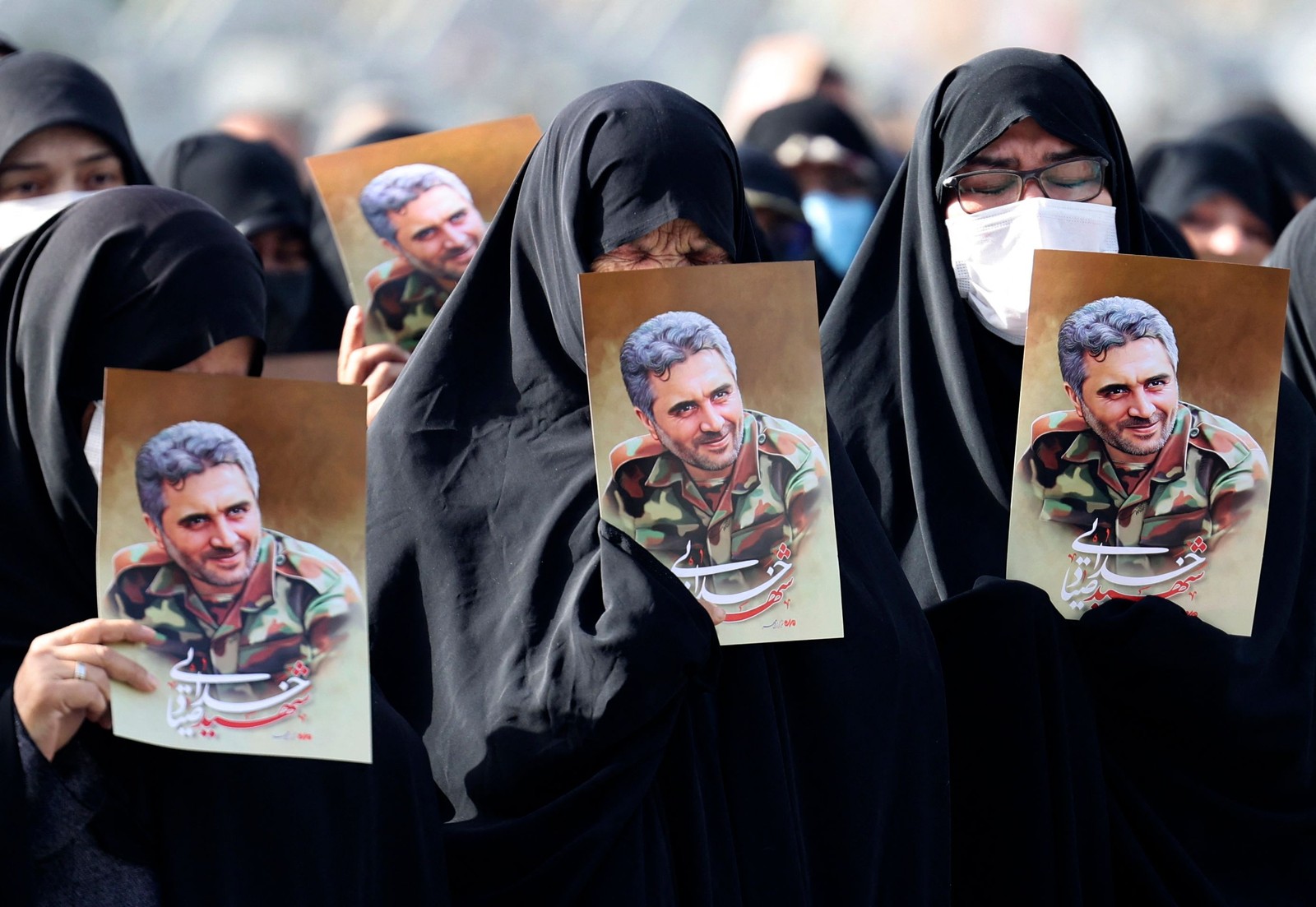 Mulheres iranianas levantam retratos do coronel Sayyad Khodai da Guarda Revolucionária durante seu cortejo fúnebre na praça Imam Hussein, na capital Teerã. Ele foi assassinado, e o Irã atribui o atentado a "elementos ligados à arrogância global" – termo da república islâmica para seu arqui-inimigo os Estados Unidos e aliados dos EUA, incluindo Israel  — Foto: ATTA KENARE / AFP
