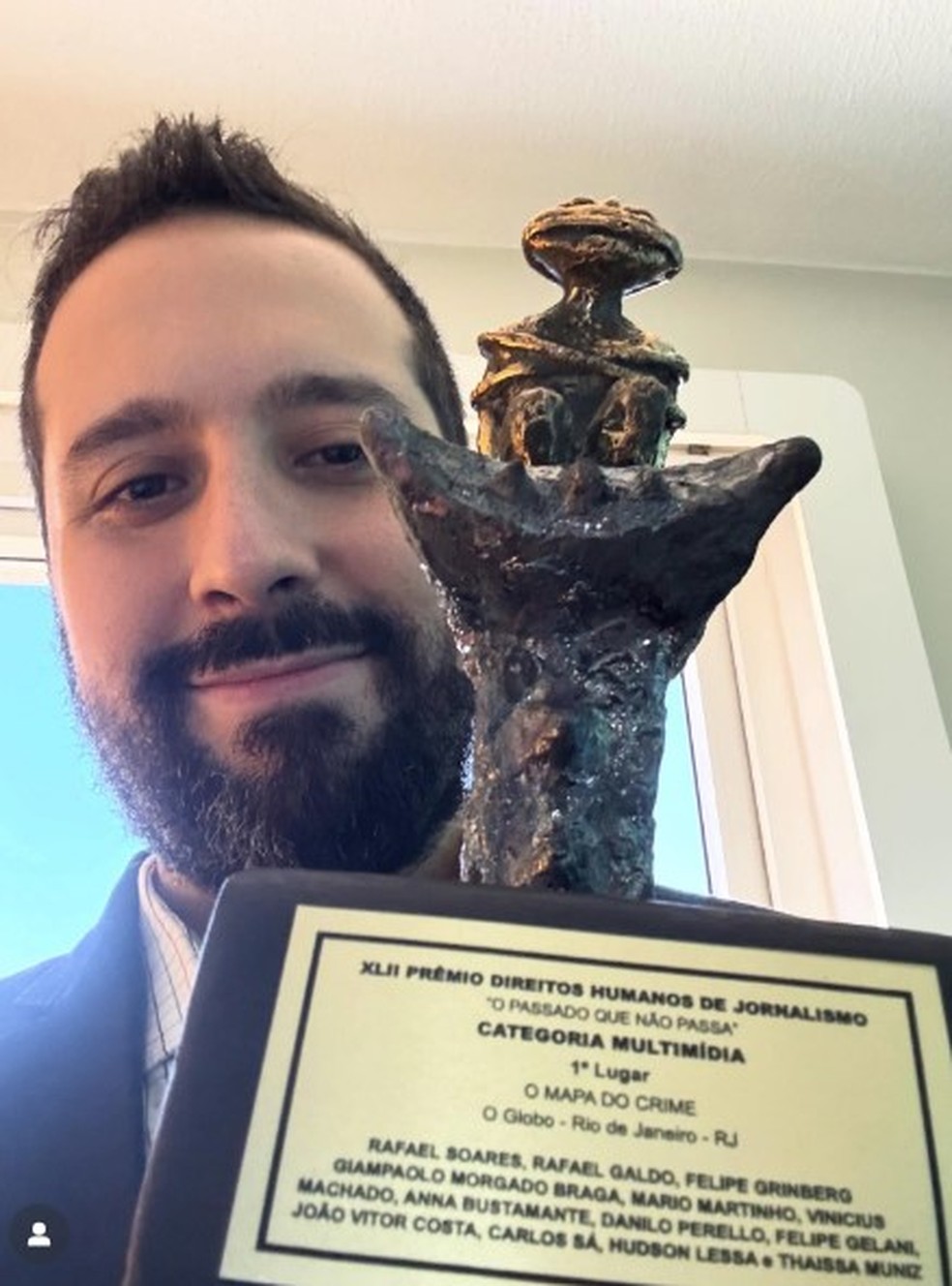 Journalist Rafael Soares presents the trophy won by the series Mapa do Crime — Photo: Personal archives