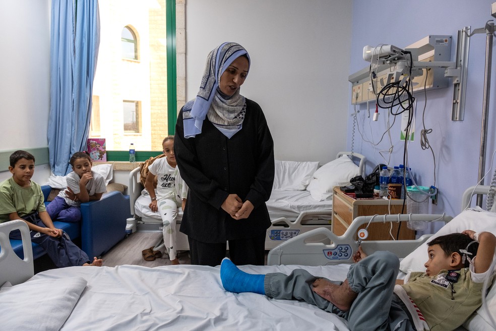 Iyad al-Masri, seis anos, no seu quarto de hospital em Abu Dhabi com a sua mãe Shireen e os seus irmãos. — Foto: Natalie Naccache/New York Times