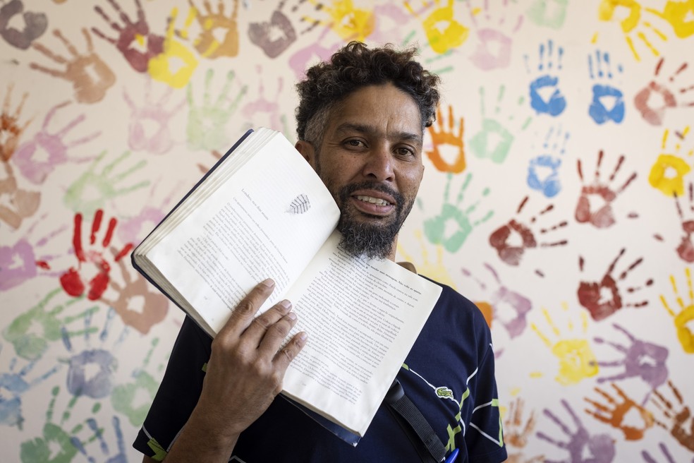 Heitor Leonardo Silva, 41 anos, veio de Belo Horizonte para o Rio e fica em abrigos. O livro é o companheiro — Foto: Márcia Foletto