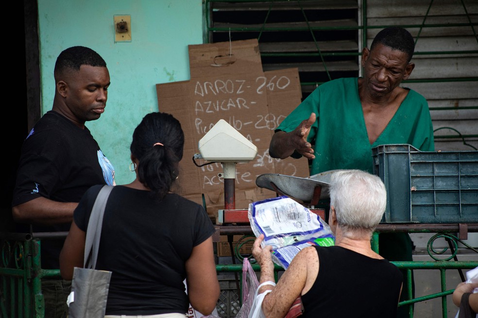Pessoas compram alimentos antes da chegada do furacão Melissa a Santiago de Cuba, em 25 de outubro — Foto: AFP