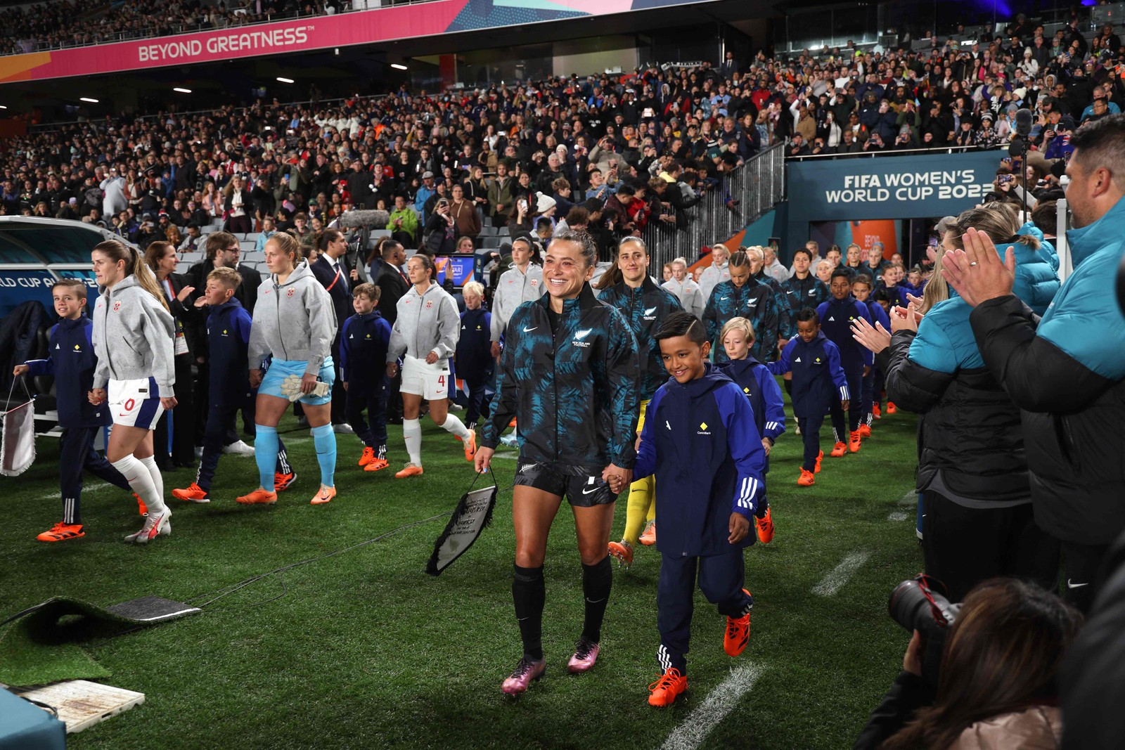 Jogadoras da Noruega e da Nova Zelândia entram em campo para a primeira partida de futebol do Grupo A da Copa do Mundo Feminina de 2023. — Foto: Marty MELVILLE / AFP 