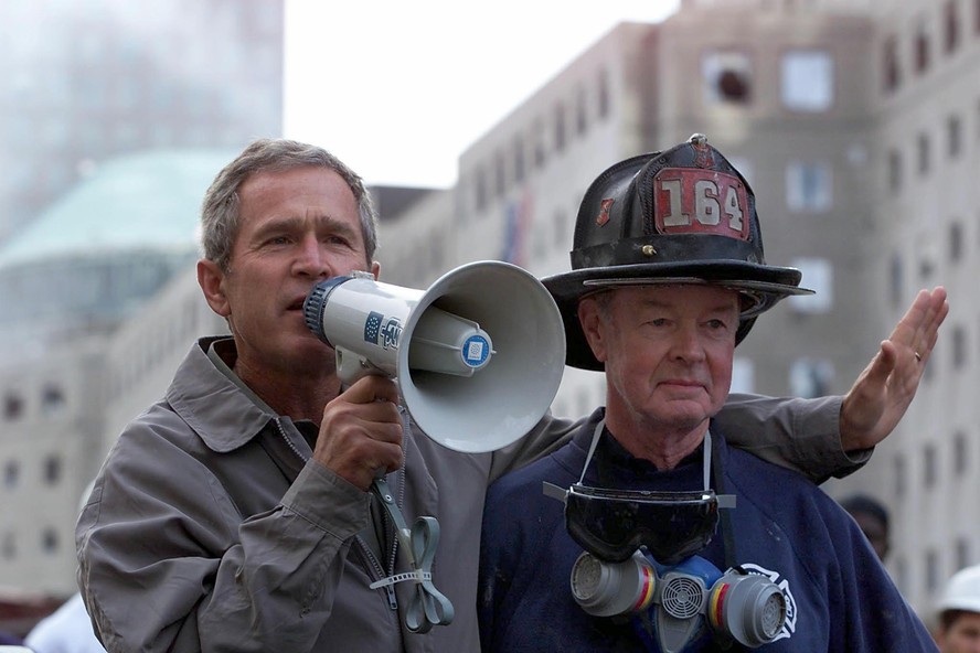 Presidente dos EUA, George W. Bush, conversa com bombeiros que trabalham no local onde ficavam as torres do World Trade Center, em Nova York