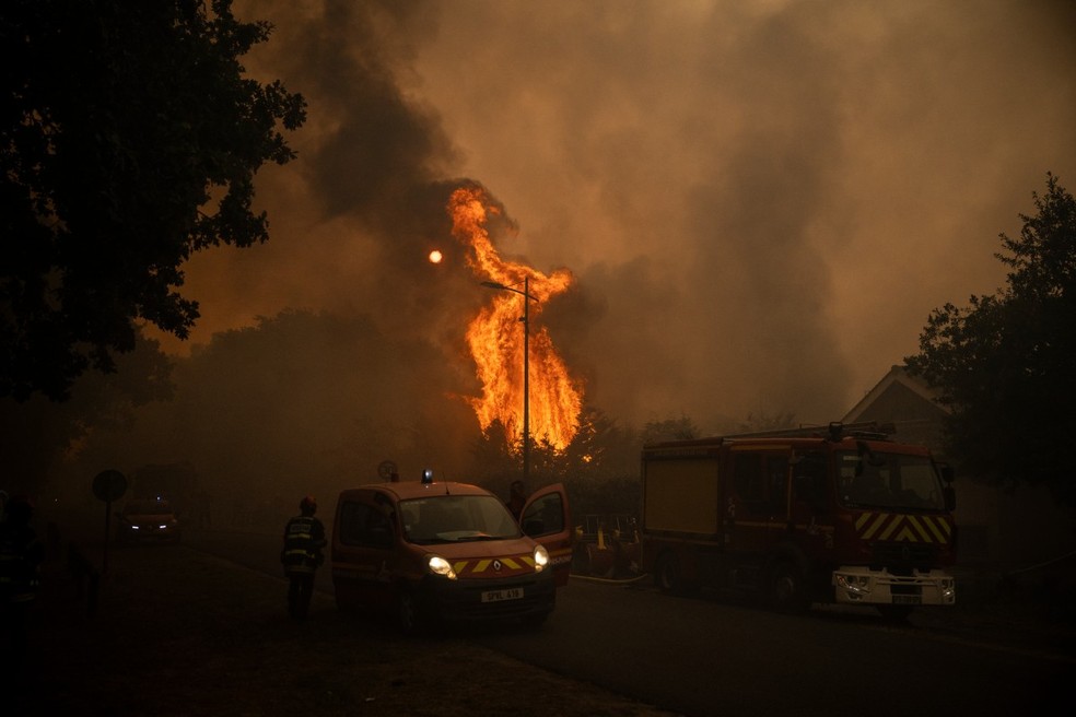 Bombeiros combatem incêndio florestal em área residencial de Lège-Cap-Ferret, no sudoeste da França, após milhares de pessoas serem evacuadas — Foto: Julien de Rosa/AFP
