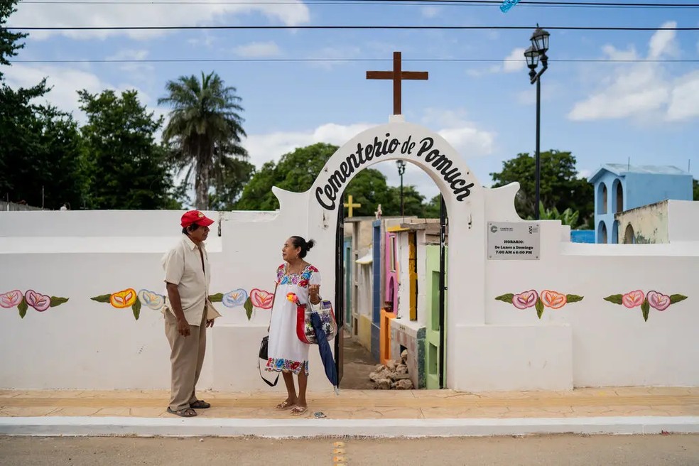 Maria Luisa Euan e seu marido Jorge Jurado após limparem ossos no cemitério de Pomuch na quinta-feira — Foto: The New York Times