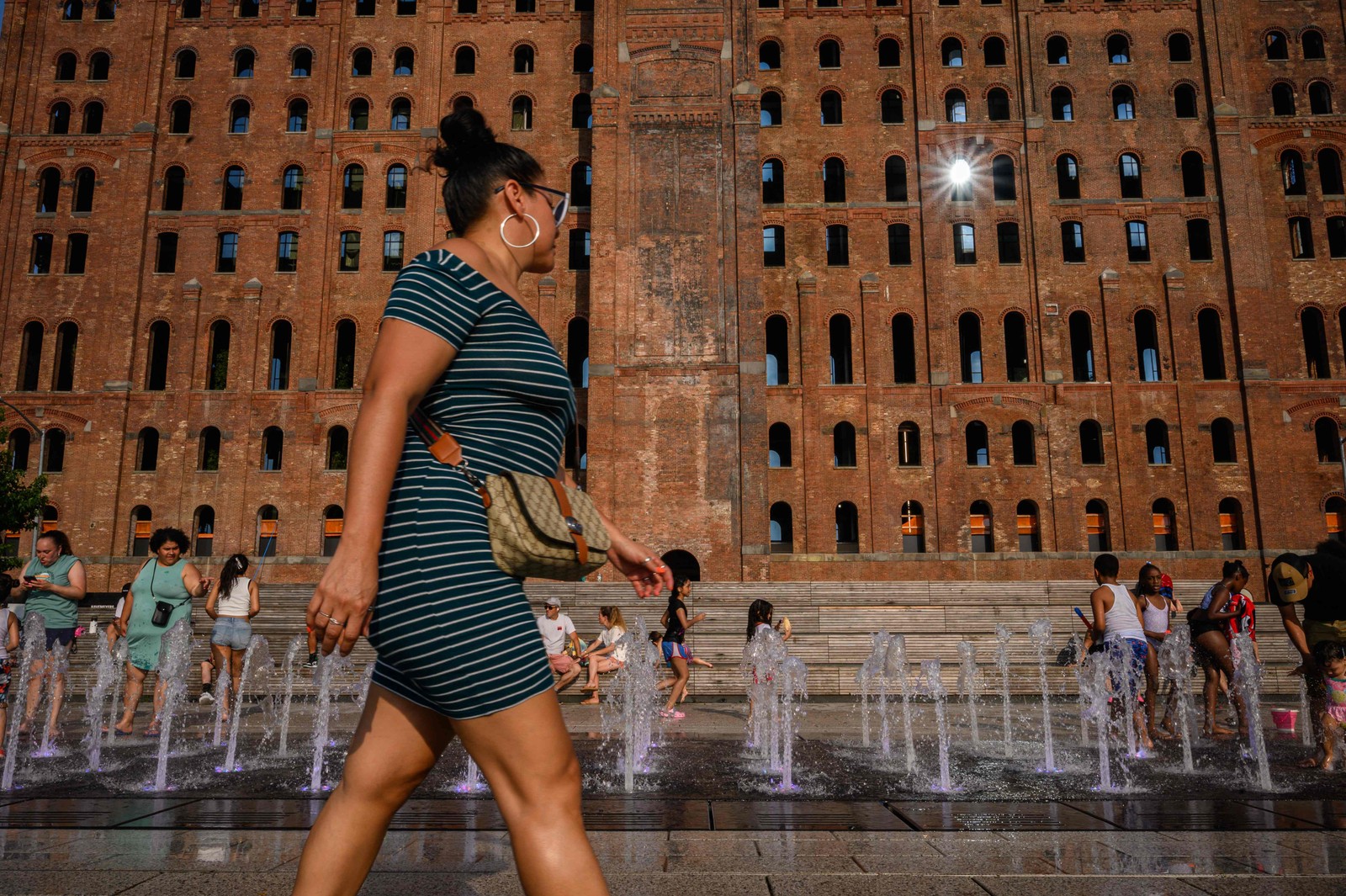 Mulher caminha diante de uma fonte de água em Nova York em 26 de julho de 2023.  — Foto: Ed JONES / AFP