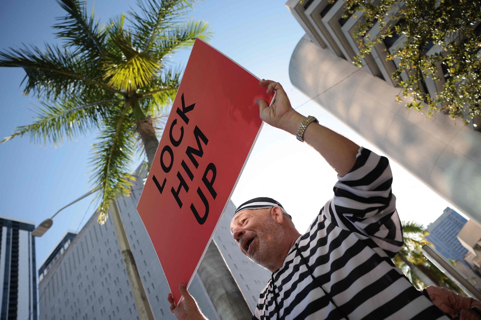 Manifestante segura uma placa escrito "tranque-o" do lado de fora do Tribunal Federal dos Estados Unidos nesta terça-feira, 13 de junho de 2023 — Foto: WIN MCNAMEE / Getty Images via AFP