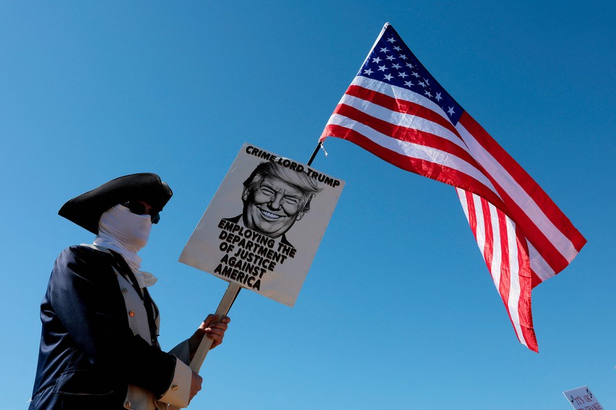 Manifestante vestido com traje histórico americano protesta, em Washington, contra ataques à democracia no governo de Donald Trump