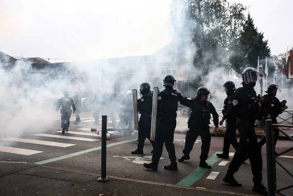 Policiais franceses com equipamento de choque mant&ecirc;m a forma&ccedil;&atilde;o em meio a uma nuvem de g&aacute;s lacrimog&ecirc;neo, enquanto estudantes realizam um protesto com bloqueio na escola de ensino m&eacute;dio Cesar Baggio, durante um dia de greves e manifesta&ccedil;&otilde;es do setor p&uacute;blico em todo o pa&iacute;s, em Lille, em 29 de setembro de 2026 &mdash; Foto: SAMEER AL-DOUMY / AFP