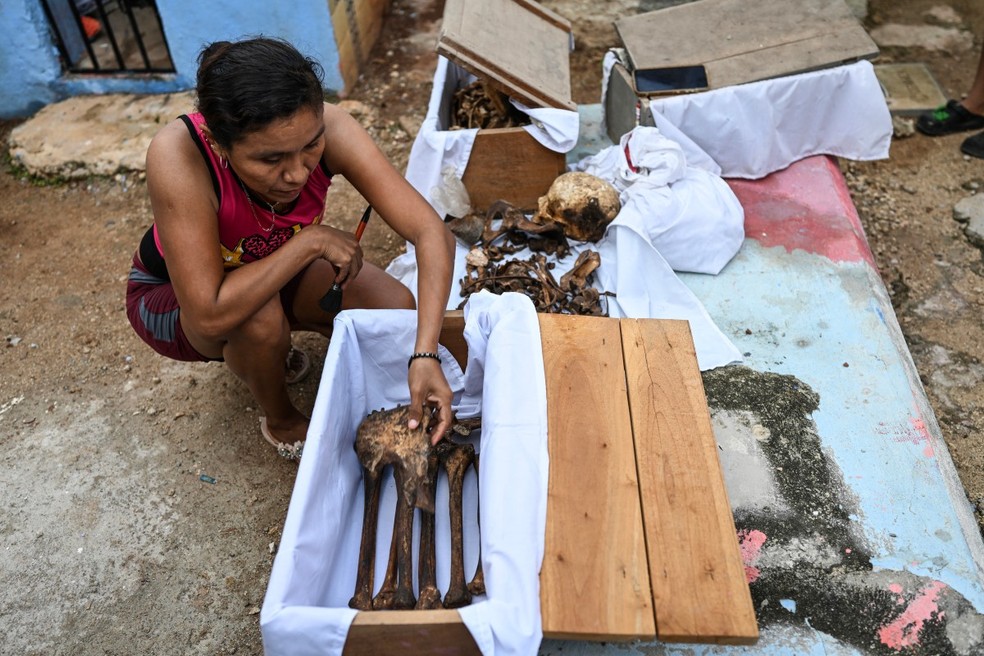 Famílias limpam ossos de parentes falecidos antes do Dia dos Mortos no México; entenda a tradição — Foto: AFP