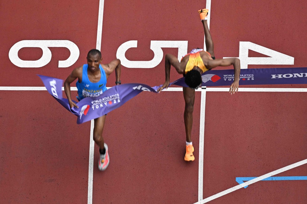 Amanal Petros cai no chão na disputa com Alphonce Felix Simbu pelo ouro da maratona — Foto: (Photo by Antonin THUILLIER / AFP)