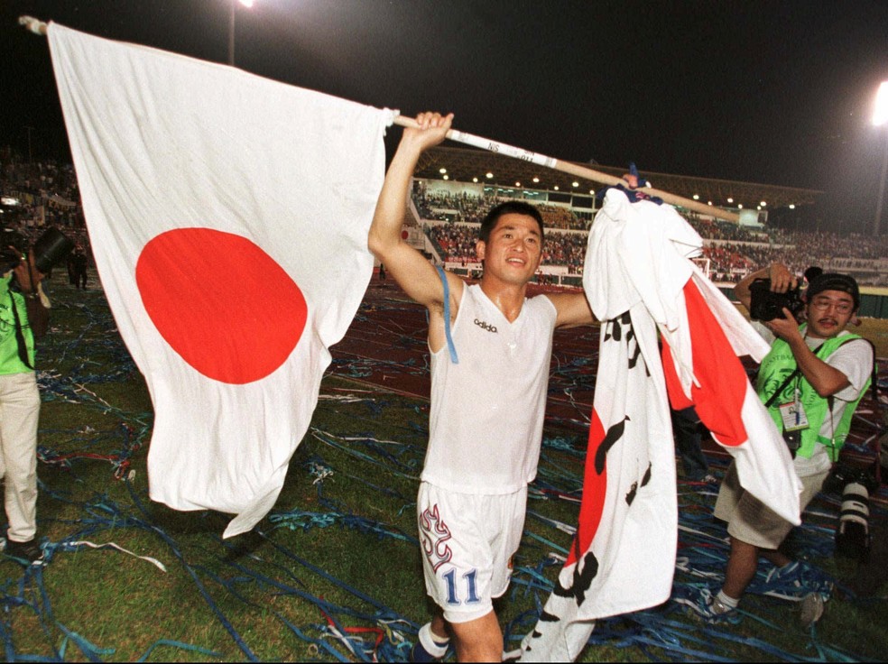 Kazu com uma bandeira do Japão após vitória contra o Irã nas eliminatórias para a Copa de 98 — Foto: AP /Mark Fallander