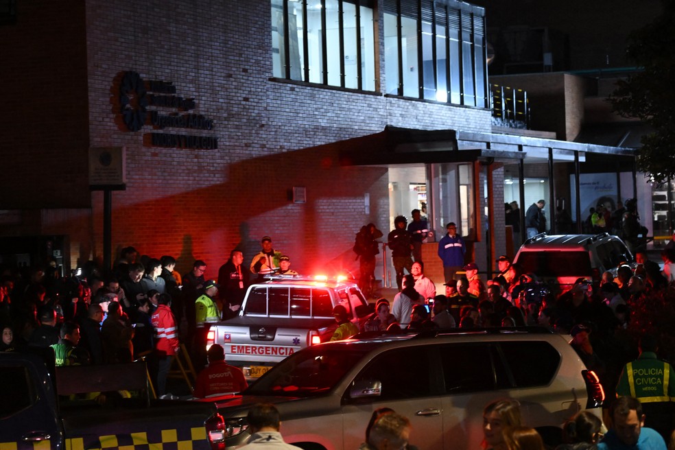 Pessoas esperam do lado de fora da Clínica Fundación Santa Fe, onde o senador Miguel Uribe Turbay está recebendo tratamento médico — Foto: AFP