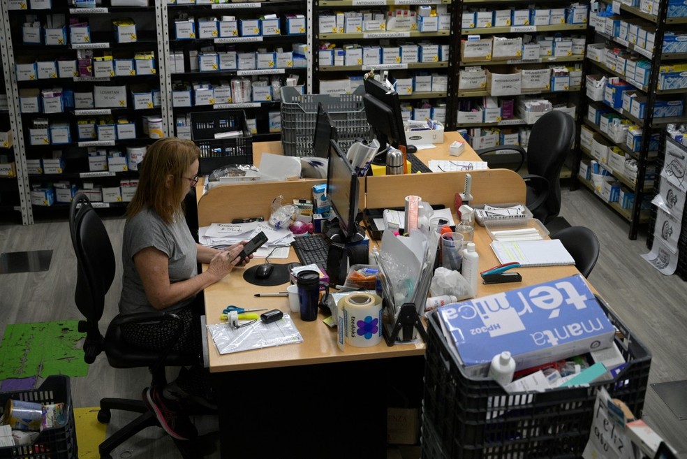 Voluntária prepara medicamentos prescritos para distribuí-los gratuitamente aos mais necessitados no Banco Comunitário de Medicamentos da Fundação Tzedaka, em Buenos Aires — Foto: JUAN MABROMATA / AFP