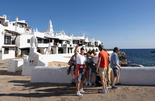 Grupo de turistas posa para foto em Binibeca Vell, o vilarejo na ilha de Menorca que ficou conhecido como 'Mykonos da Espanha'