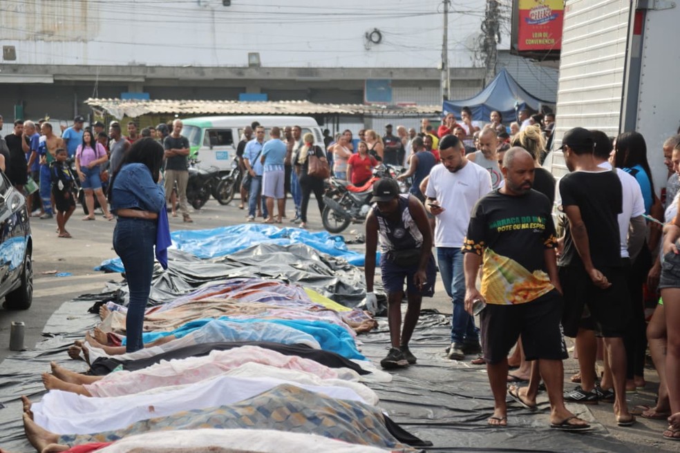Moradores levam 40 corpos para praça do Complexo da Penha. Rio — Foto: Fabiano Rocha
