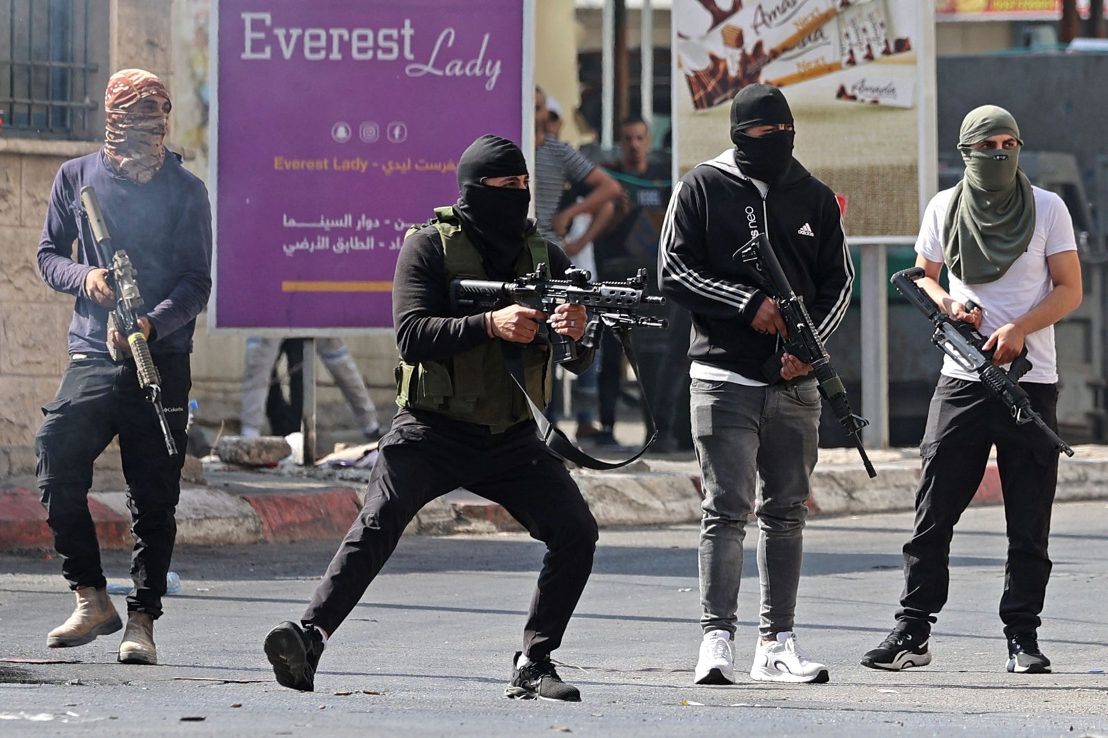 Combatentes palestinos disparam contra veículos blindados israelenses na cidade ocupada de Jenin, na Cisjordânia, em 3 de julho de 2023 — Foto: Jaafar ASHTIYEH / AFP