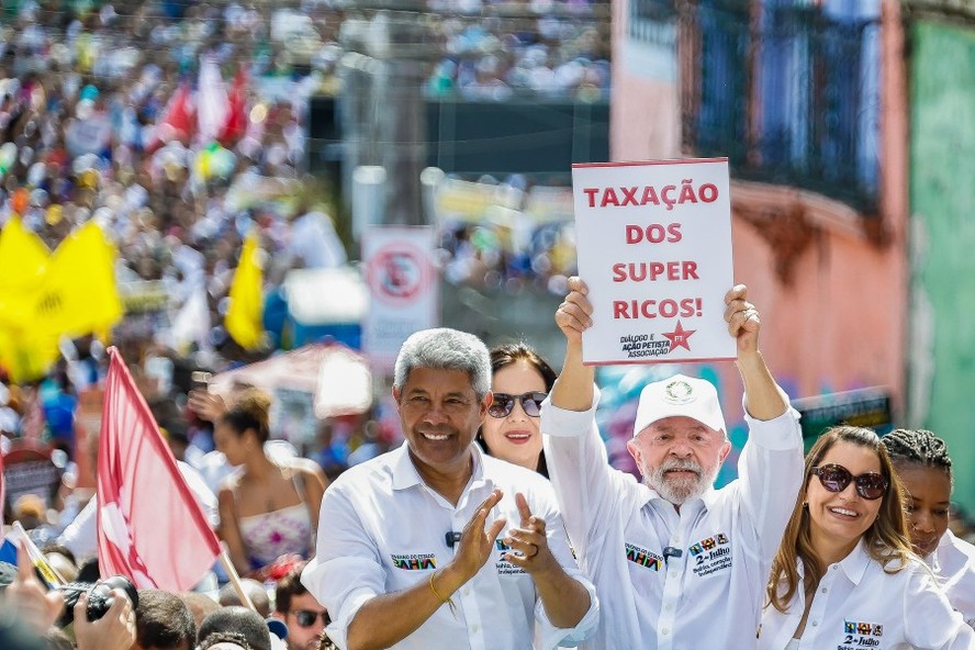 Lula levanta placa pedindo taxa&ccedil;&atilde;o dos super ricos durante caminhada em Salvador