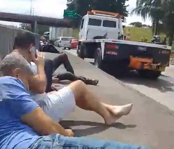 Drivers take shelter on the wall of Avenida Brasil during filming — Photo: Video reproduction