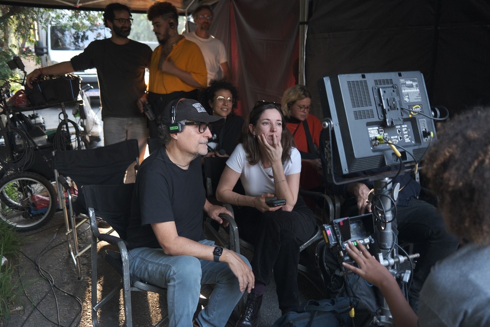 Diretor Kleber Mendonça Filho e produtora Emilie Lesclaux durante as filmagens de "O agente secreto" — Foto: Divulgação / Gustavo Baez