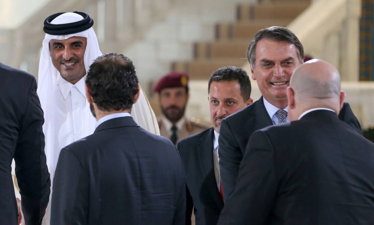 Bolsonaro e xeique Tamim bin Hamad al-Thani cumprimentam funcionários em Doha — Foto: AFP