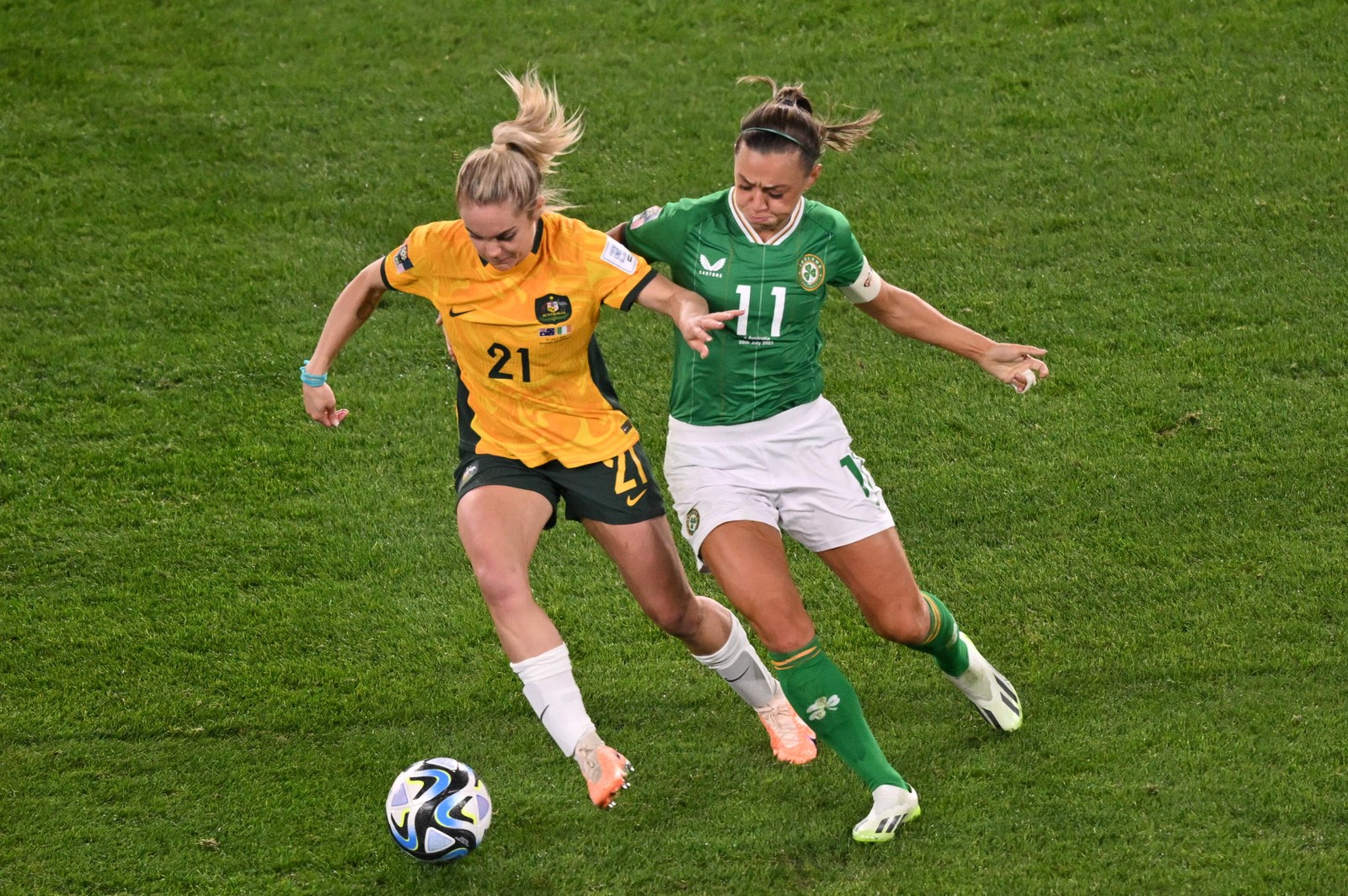 A zagueira australiana Ellie Carpenter e a meio-campista irlandesa Katie McCabe disputam a bola durante a primeira partida do Grupo B — Foto: Izhar KHAN / AFP