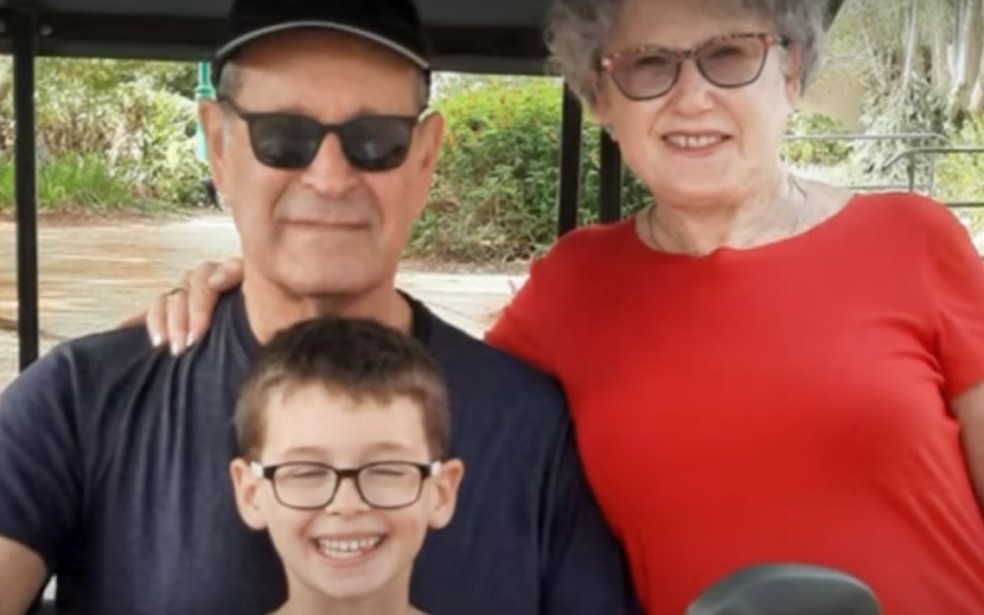 Avhram Munder, sua esposa Ruti, 78, com o neto, Ohad, 9. Eles foram levados de dentro do bunker em que a família buscou abrigo durante ataque do Hamas no Kibbutz Nir Oz, em 7 de Outubro de 2024. — Foto: Reprodução