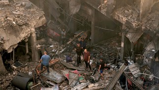 Palestinos analisam a destruição após o bombardeio israelense no sul da Faixa de Gaza, em 15 de novembro de 2023. Mais de 10.000 pessoas foram mortas em bombardeios israelenses implacáveis na Faixa de Gaza, de acordo com o Ministério da Saúde administrado pelo Hamas — Foto: MAHMUD HAMS / AFP