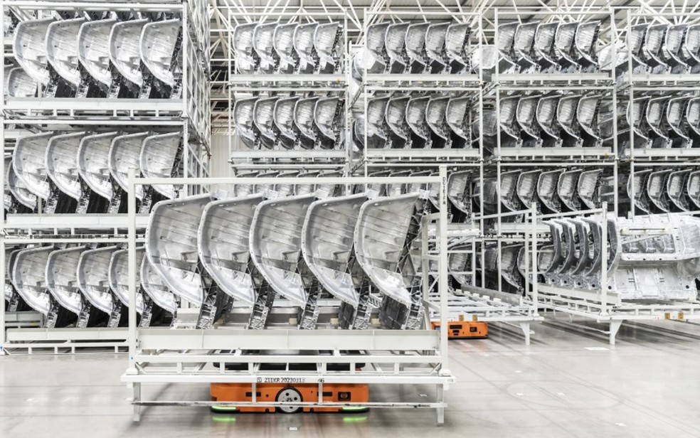 Um carrinho robótico transportando peças de carroceria na fábrica de montagem de carros elétricos na China — Foto: Qilai Shen/The New York Times