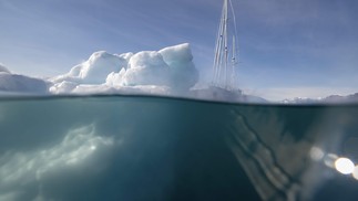 Barco à vela 'Kamak' da expedição da Groenlândia navega entre icebergs liberados por geleiras ao redor de Milne Land no fiorde Scoresby Sound, leste da Groenlândia. O Centro Nacional Francês de Pesquisa Científica está realizando uma expedição para explorar os fiordes isolados da Groenlândia, os maior sistema de fiordes, que permanece muito pouco estudado. — Foto: Olivier MORIN/AFP