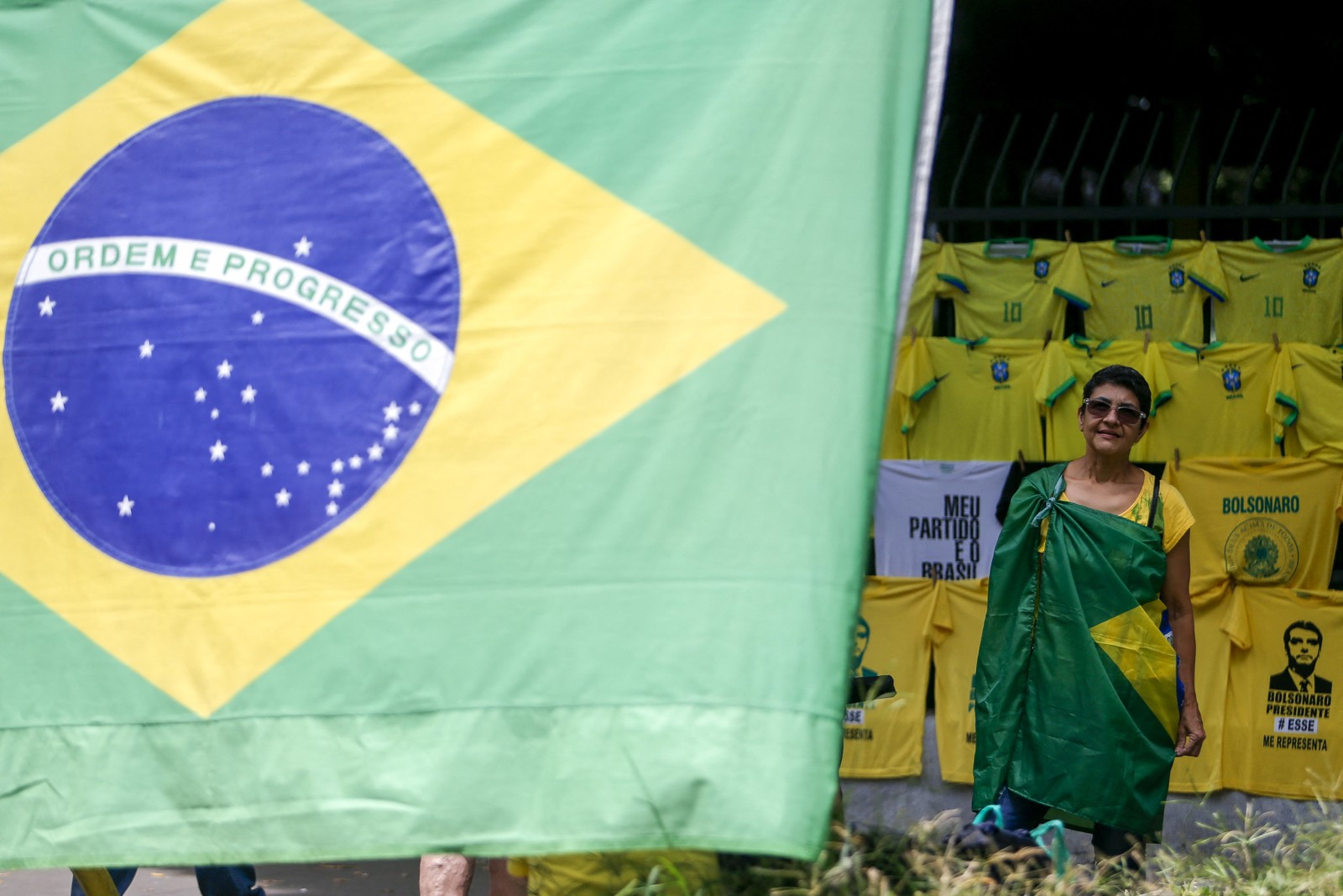 Manifestantes vestem camisas verde e amarelo, além de estenderem bandeiras do Brasil, de Israel e de Bolsonaro — Foto: Miguel SCHINCARIOL / AFP