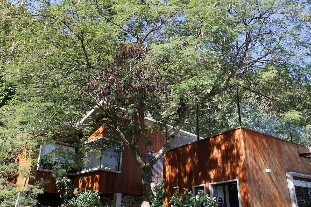 Madeira, ferro e concreto são materiais marcantes do projeto da casa — Foto: Reprodução/Airbnb