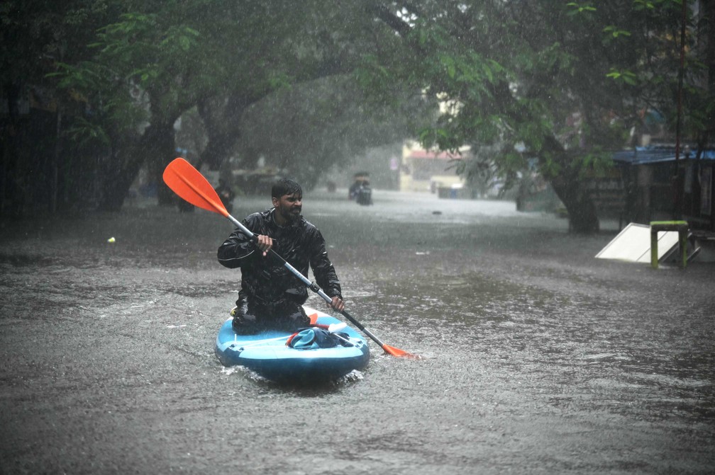 Em Chennai, na Índia, pessoas tiveram que recorrer a caiaques para se locomover pelas ruas — Foto: R. SATISH BABU / AFP