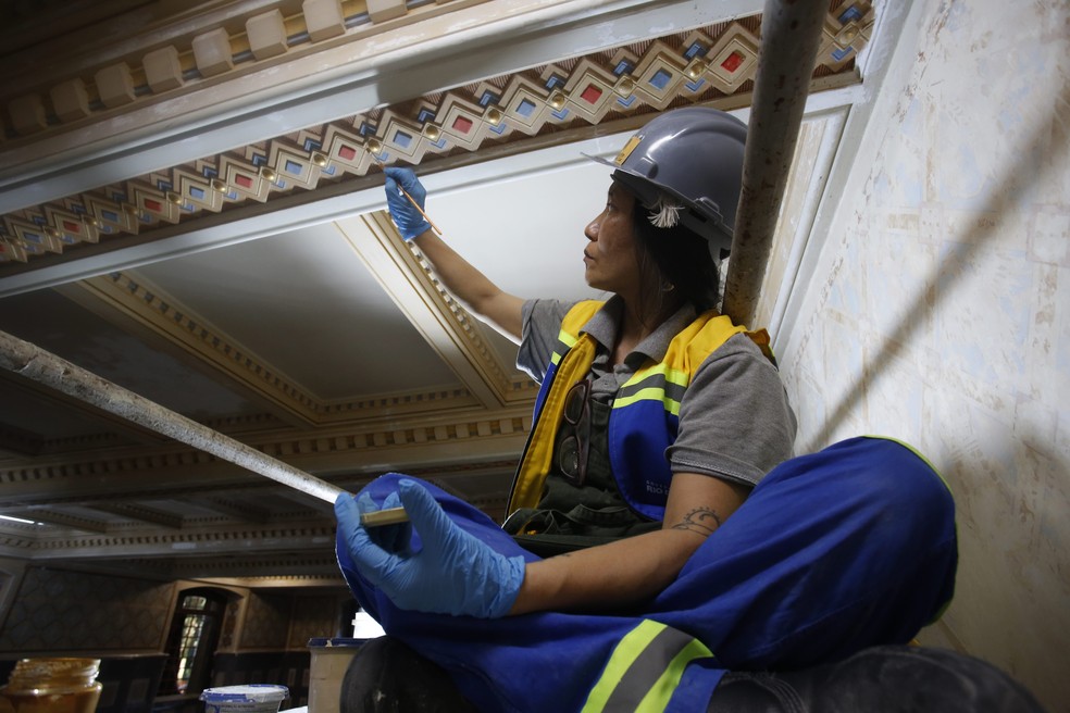 Restauradora trabalha em parte do teto do palacete — Foto: Custodio Coimbra