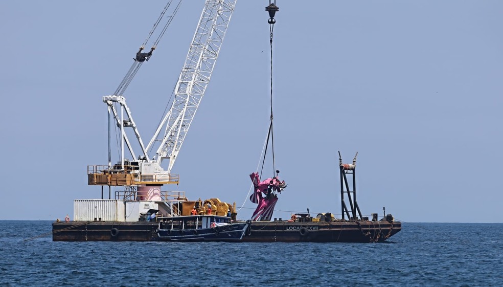 O avião sendo colocado no rebocador — Foto: Fabiano Rocha/Agência O Globo