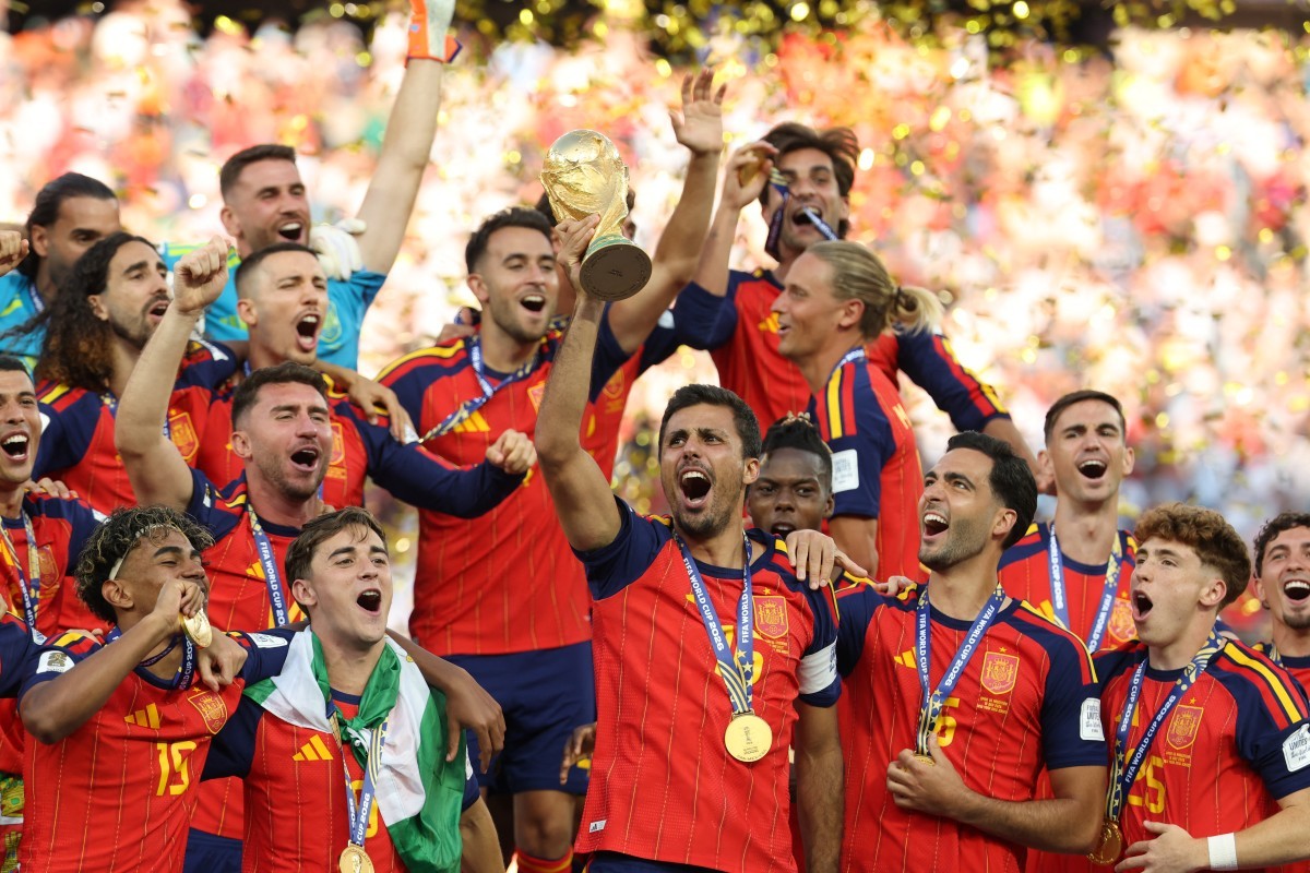 O meio-campista espanhol número 16, Rodri, ergue o troféu com seus companheiros de equipe após a vitória na final da Copa do Mundo de 2026 entre Espanha e Argentina — Foto: JUAN MABROMATA / AFP
