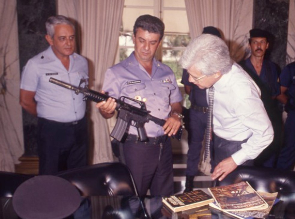 Moreira Franco observa fuzil Colt AR-15 apreendido com traficantes, em 1989 — Foto: Manoel Soares/Agência O GLOBO