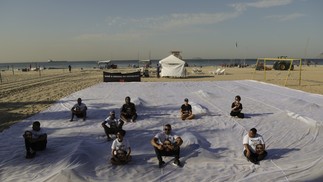 Parentes e voluntários no protesto na praia — Foto: Gabriel de Paiva / Agência O Globo