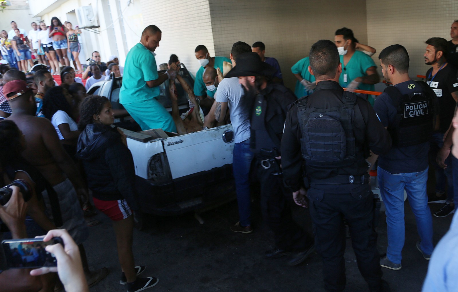 Equipe do Hospital Getúlio Vargas retira da caçamba de um carro o corpo de homem morto durante a ação policial na Penha  — Foto: Reprodução