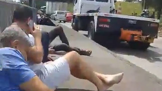Drivers take shelter on the wall of Avenida Brasil during filming — Photo: Video reproduction