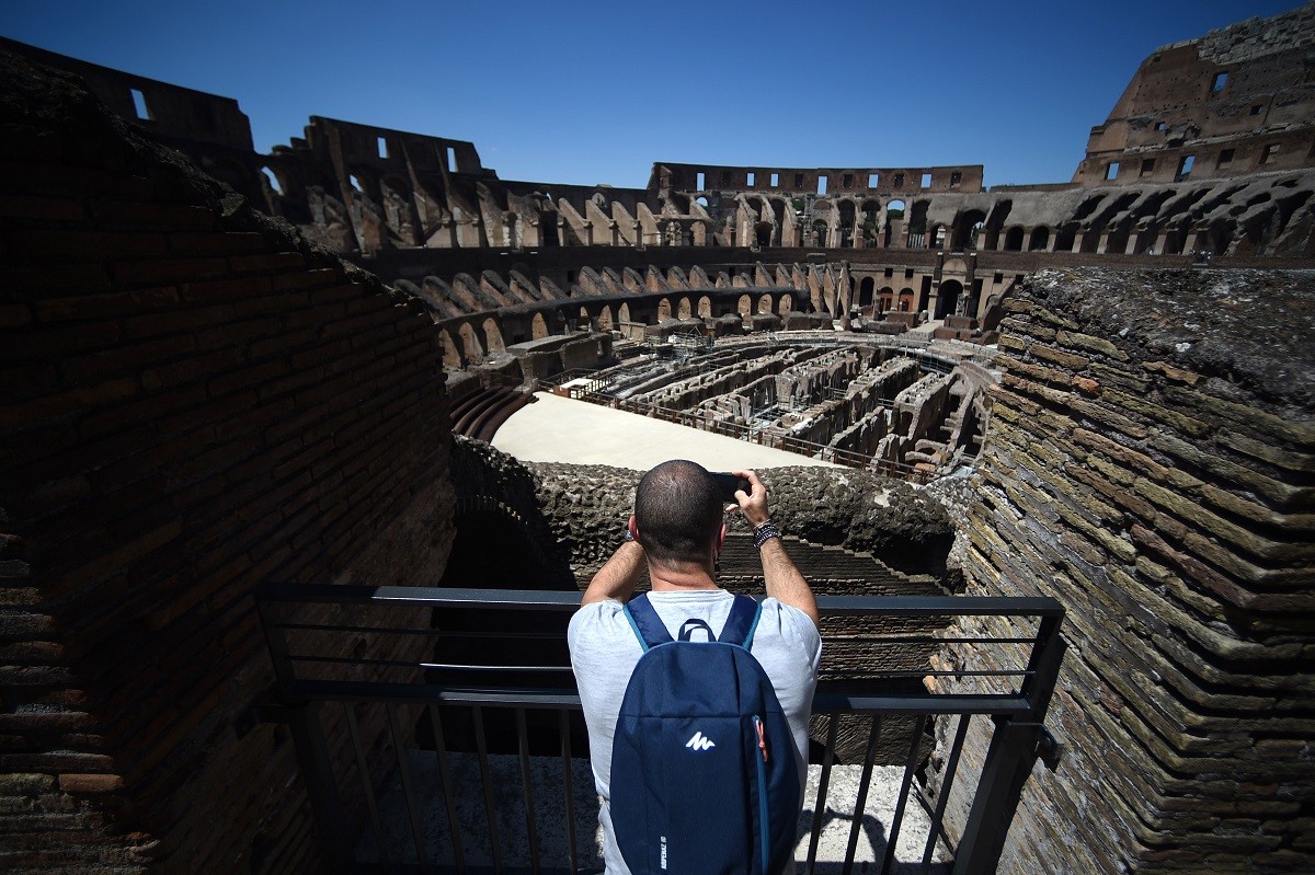 Turista fotografa o Coliseu de Roma, reaberto em 1 de junhoAFP