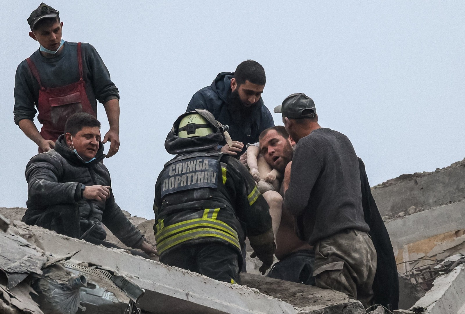 Diversas pessoas trabalharam nos locais atingidos na tentativa de resgatar possíveis vítimas — Foto: Anatolii Stepanov / AFP