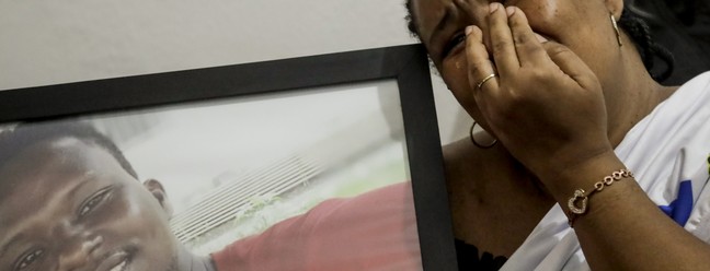 Sofrimento. Lotsove Lolo Lavy Ivone, comerciante congolesa, no Rio desde 2014, abraça o retrato do filho, que foi assassinado na Praia da Barra depois de escapar da guerra em sua terra natal Agência O Globo