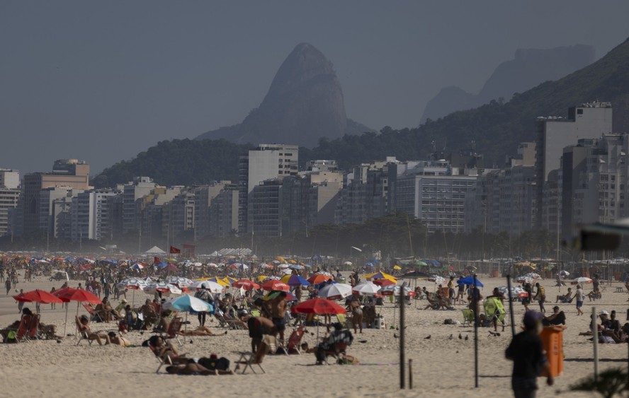 Pôr do sol em praia brasileira com pessoas aproveitando o momento