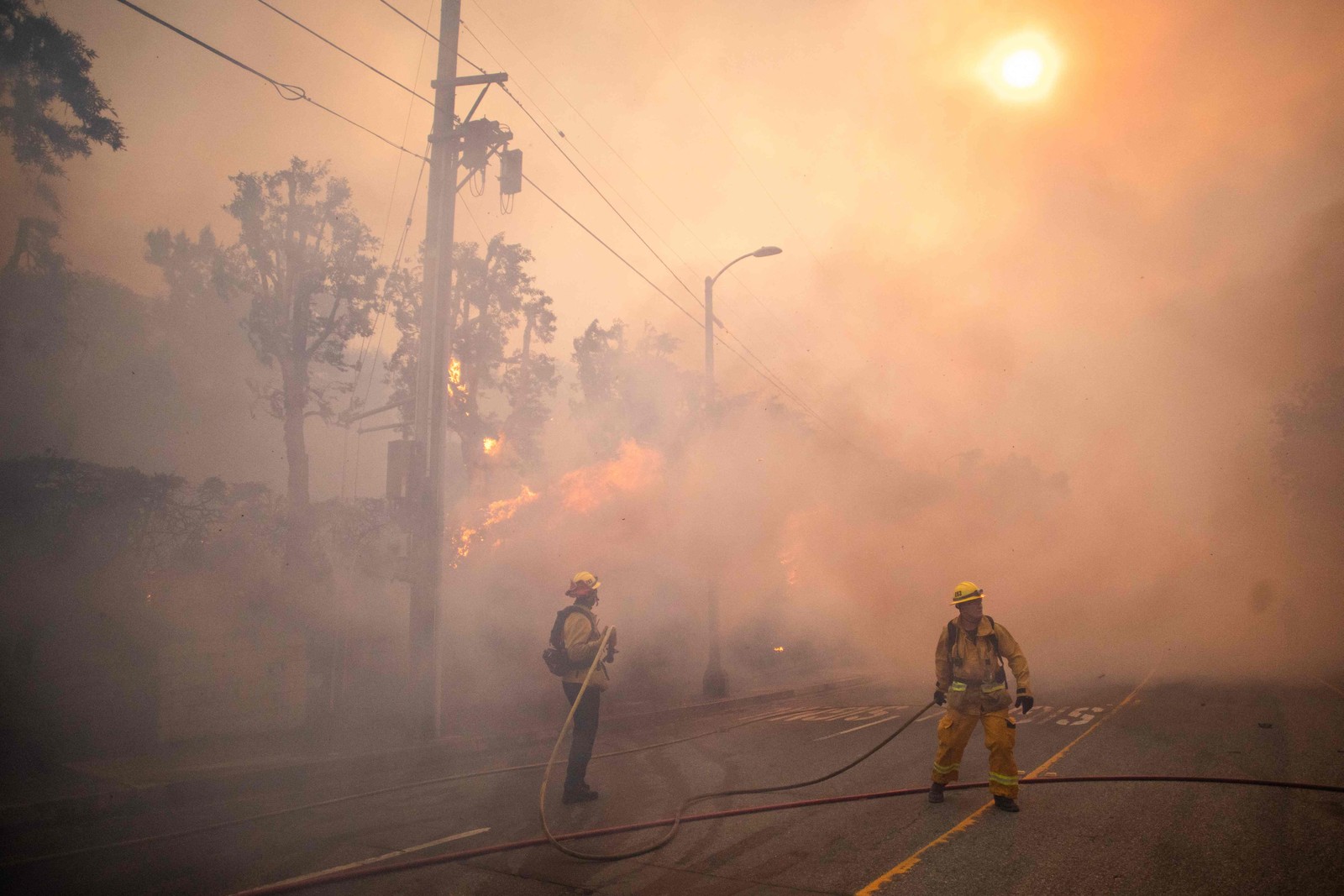 Bombeiros trabalham em trecho da Sunset Boulevard — Foto: Apu Gomes/Getty Images/AFP
