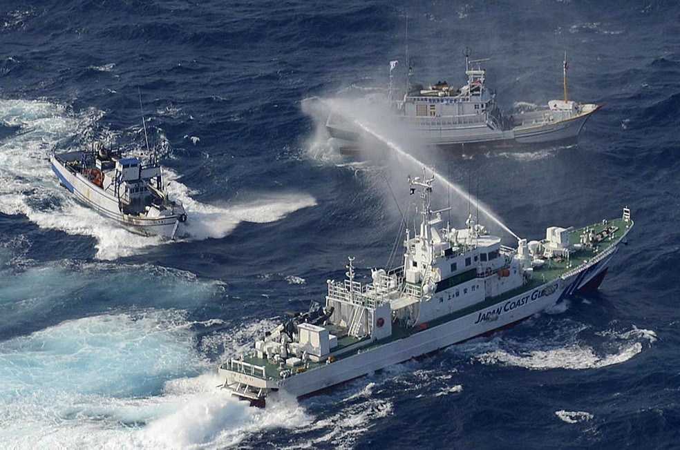 Barco da Guarda Costeira japonesa usa jatos d'água para afastar barco pesqueiro taiwanês das proximidades das Ilhas Senkaku / Ilhas Diaoyu — Foto: YOMIURI SHIMBUN/AFP